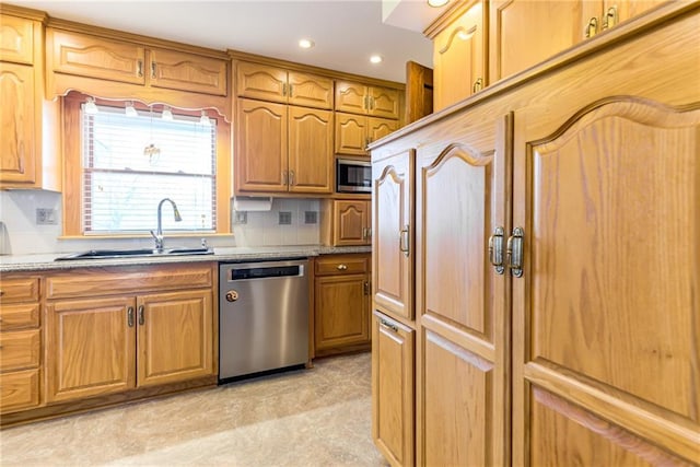 kitchen featuring stainless steel appliances, sink, and backsplash