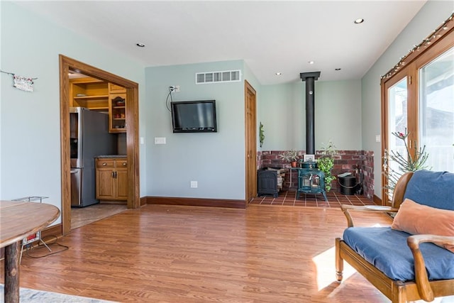 sitting room with hardwood / wood-style floors and a wood stove