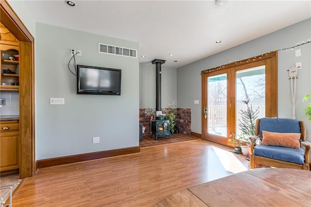 living area featuring light wood-type flooring and a wood stove