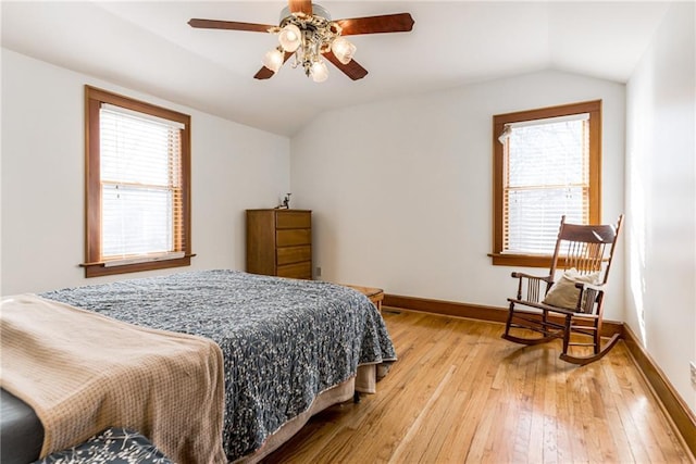 bedroom with multiple windows, vaulted ceiling, ceiling fan, and light hardwood / wood-style flooring