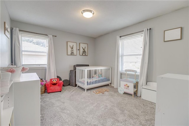 bedroom featuring a crib and light carpet