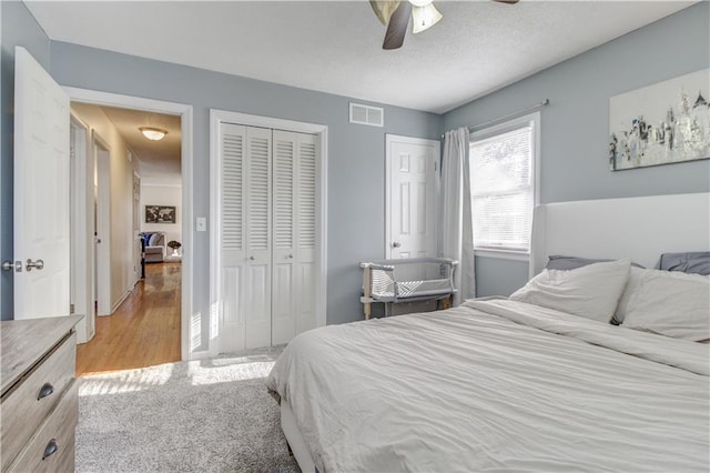 carpeted bedroom with ceiling fan and two closets