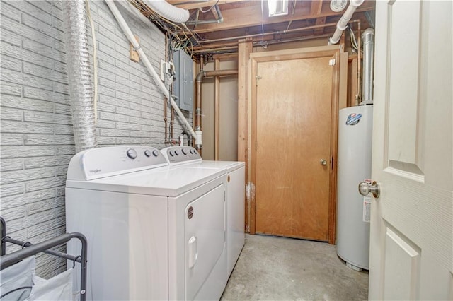 washroom with electric panel, brick wall, gas water heater, and washing machine and dryer