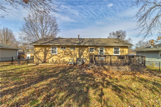 rear view of house with a deck and a yard