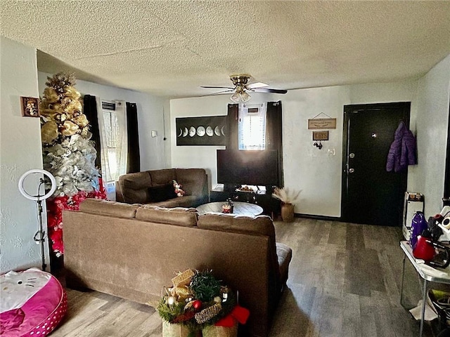 living room featuring ceiling fan, wood-type flooring, and a textured ceiling