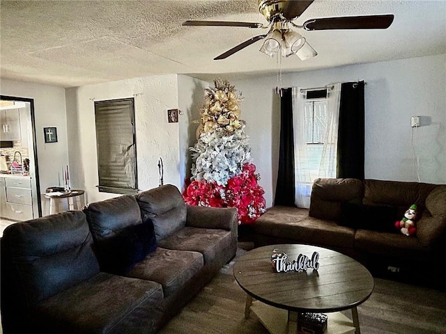 living room with hardwood / wood-style flooring, ceiling fan, sink, and a textured ceiling