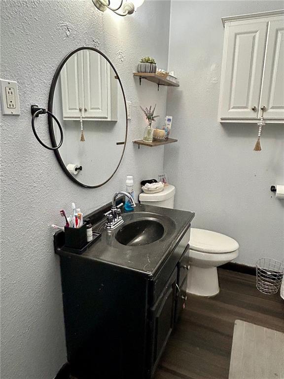 bathroom with vanity, wood-type flooring, and toilet