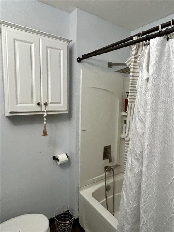 bathroom with shower / bath combo and toilet