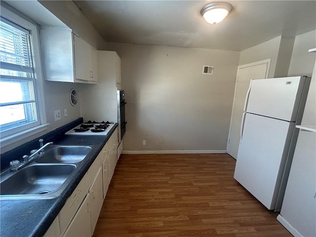 kitchen featuring white cabinets, dark hardwood / wood-style floors, white appliances, and sink