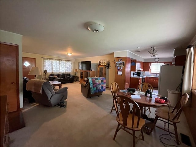 dining area featuring light carpet