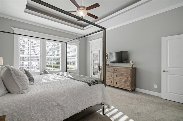 bedroom with ceiling fan, crown molding, light colored carpet, and a tray ceiling