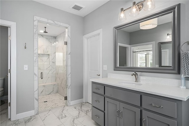 bathroom featuring a shower with shower door, toilet, and vanity