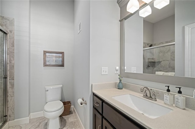 bathroom featuring toilet, vanity, and a shower with shower door