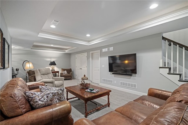 living room with ornamental molding, light colored carpet, and a tray ceiling