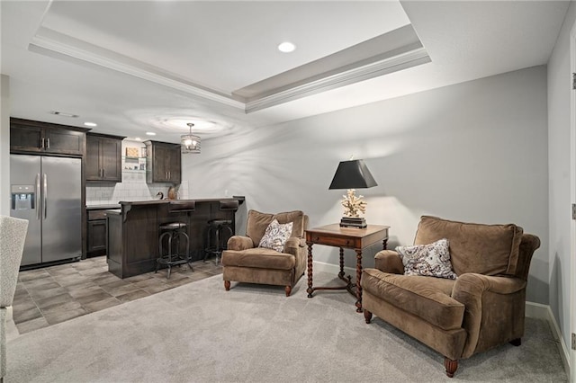 sitting room with light colored carpet and a raised ceiling