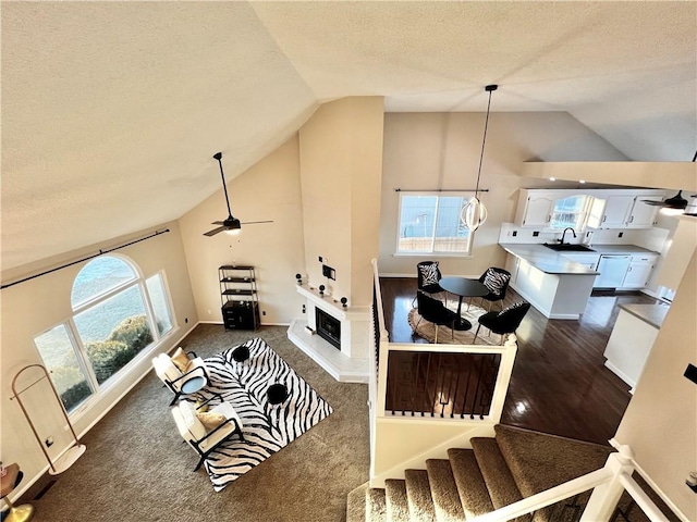 living room with sink, vaulted ceiling, and a textured ceiling