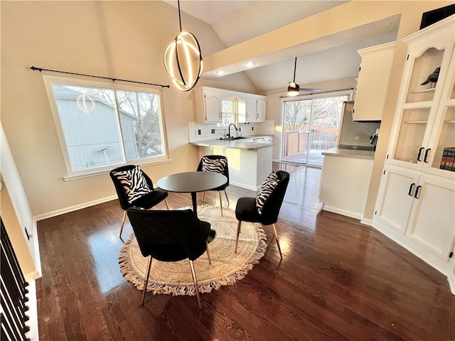 dining space featuring dark hardwood / wood-style floors, sink, vaulted ceiling, and a wealth of natural light