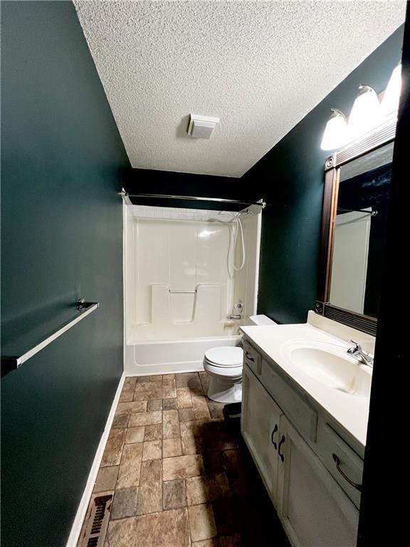 full bathroom featuring vanity, toilet, shower / bath combination, and a textured ceiling