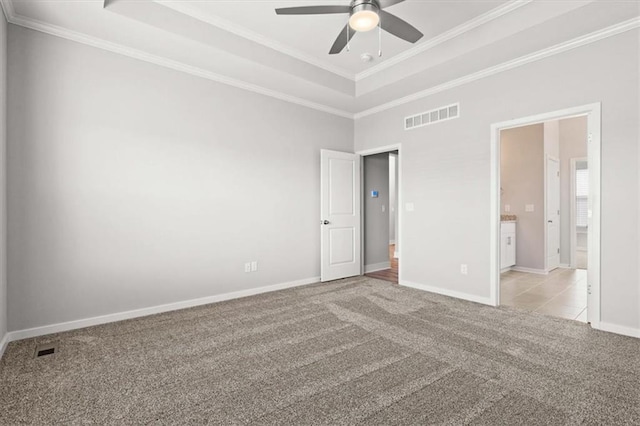 carpeted spare room with crown molding, ceiling fan, and a tray ceiling