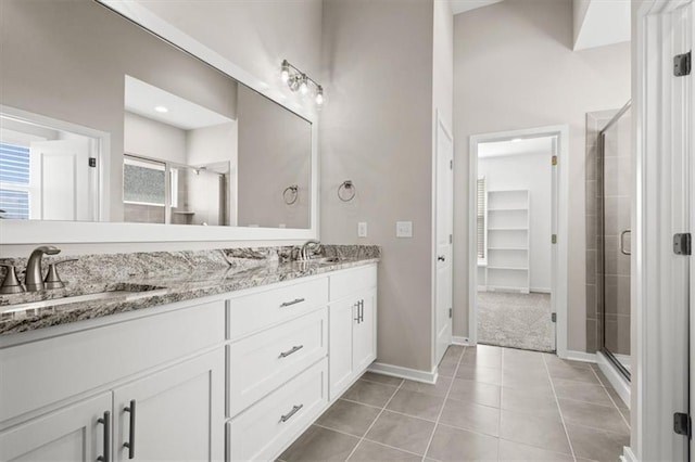 bathroom featuring tile patterned flooring, vanity, and a shower with door