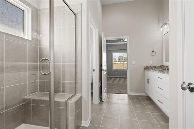 bathroom with tile patterned flooring, vanity, and walk in shower