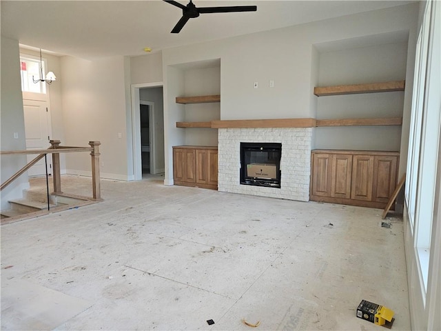 5005 146th St, Basehor, KS 66007 - unfurnished living room featuring built in features, a brick fireplace, a chandelier, and ceiling fan