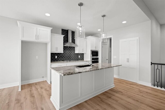 5005 146th St, Basehor, KS 66007 - kitchen with wall chimney exhaust hood, appliances with stainless steel finishes, white cabinetry, light wood-type flooring, and recessed lighting