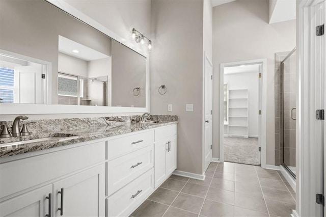 5005 146th St, Basehor, KS 66007 - bathroom featuring double vanity, a shower stall, tile patterned flooring, and a spacious closet