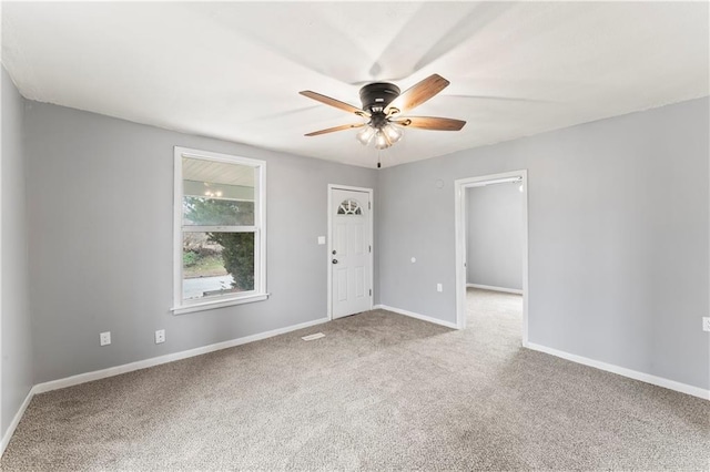 empty room with ceiling fan and light carpet