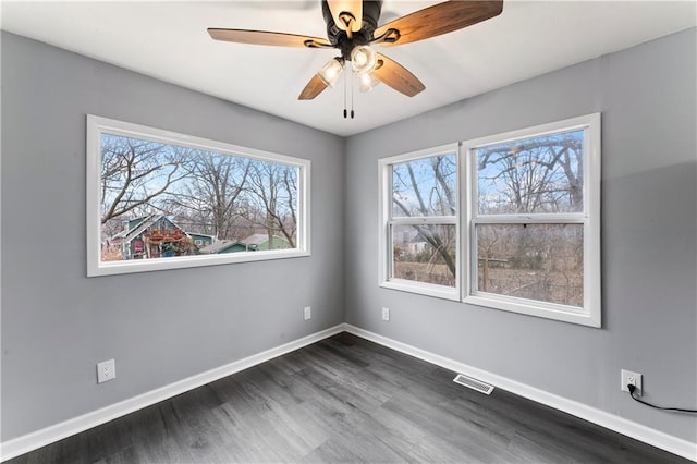 spare room with dark wood-type flooring and ceiling fan