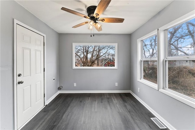 empty room with ceiling fan and dark hardwood / wood-style floors