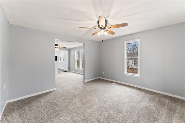 carpeted spare room featuring ceiling fan