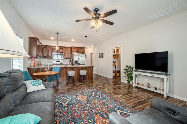 living room featuring dark wood-type flooring and ceiling fan