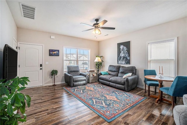 living room with dark wood-type flooring and ceiling fan