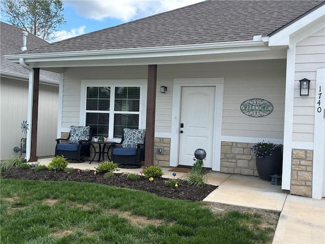 1740 S Park Dr, Tonganoxie, KS 66086 - property entrance with covered porch, stone siding, and roof with shingles