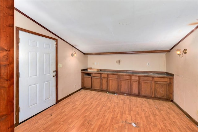 kitchen with lofted ceiling, ornamental molding, and light hardwood / wood-style flooring