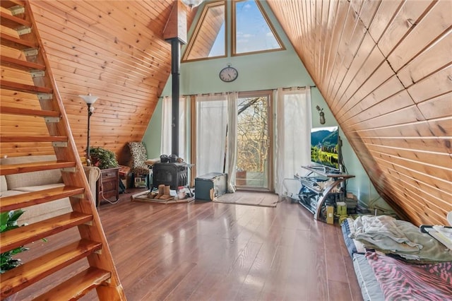 additional living space featuring lofted ceiling, stairway, wood ceiling, a wood stove, and wood finished floors