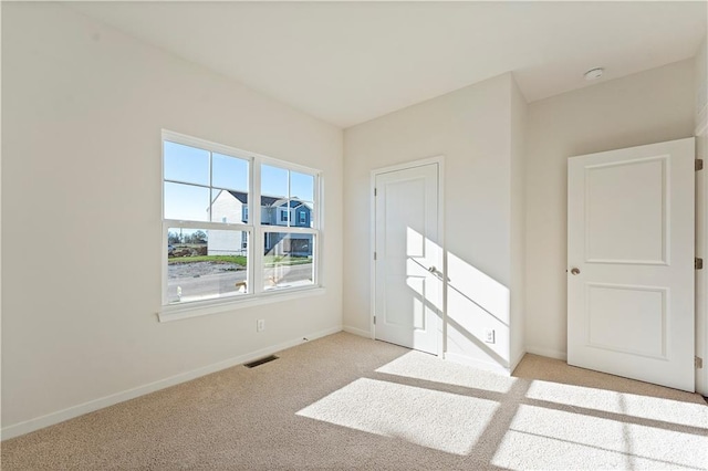 spare room featuring light carpet