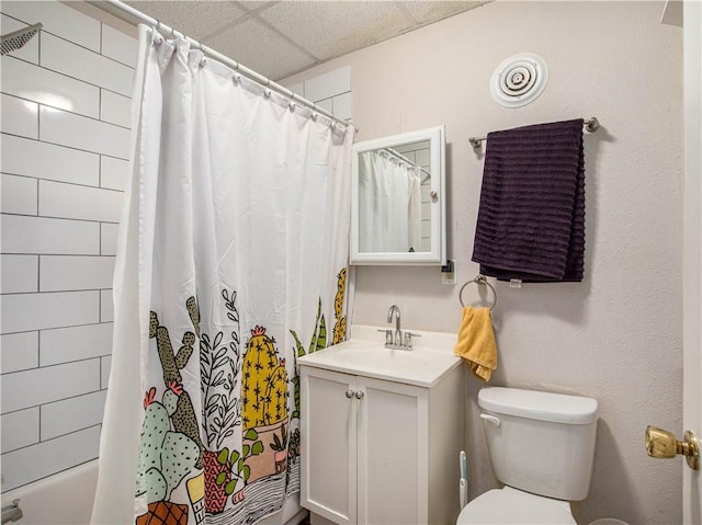 bathroom featuring vanity, toilet, and a drop ceiling