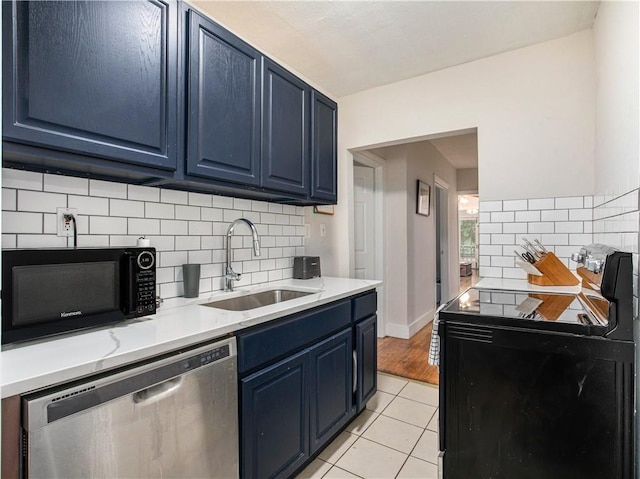 kitchen with decorative backsplash, blue cabinets, sink, black appliances, and light tile patterned floors