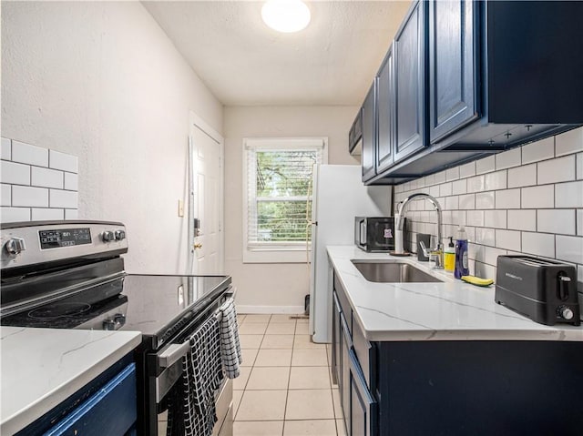 kitchen featuring light stone counters, sink, blue cabinetry, light tile patterned floors, and electric range