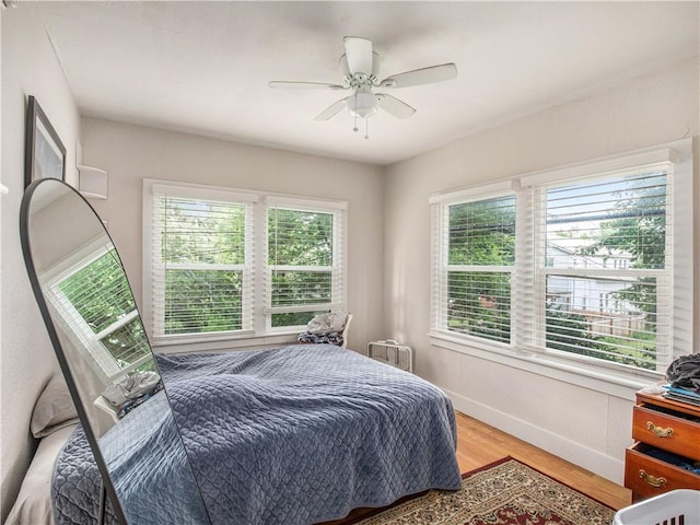 bedroom featuring multiple windows, ceiling fan, and hardwood / wood-style flooring