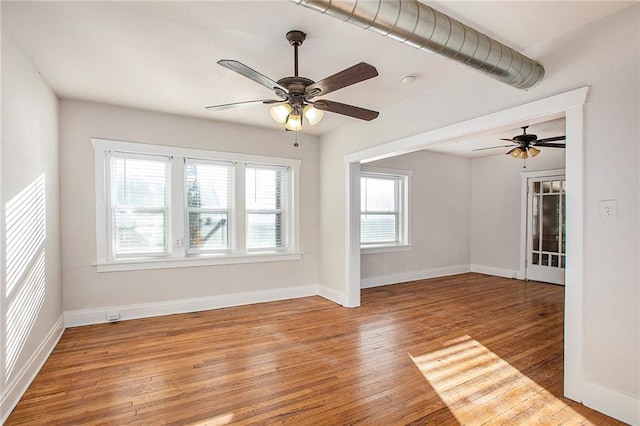 unfurnished living room featuring hardwood / wood-style flooring, a wealth of natural light, and ceiling fan