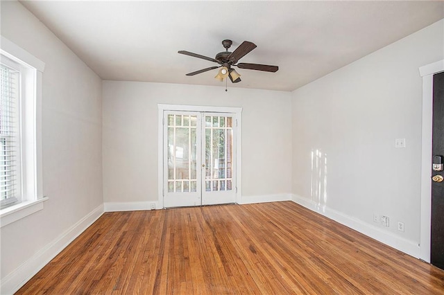 empty room featuring hardwood / wood-style floors, ceiling fan, and a wealth of natural light