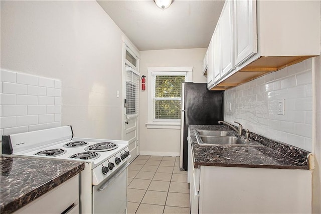 kitchen featuring backsplash, sink, electric stove, light tile patterned floors, and white cabinetry