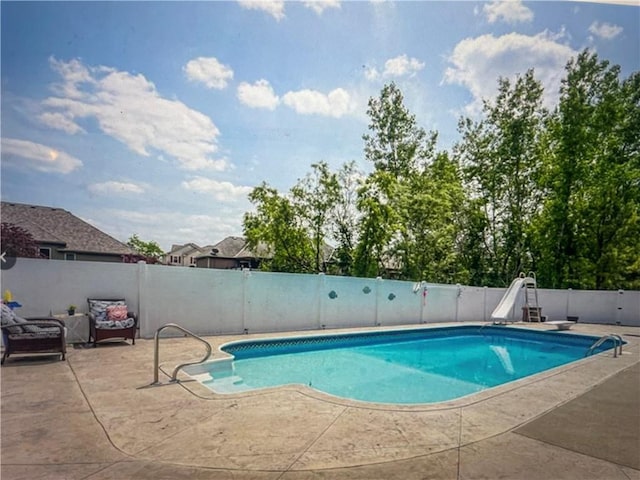 view of swimming pool with a patio and a water slide