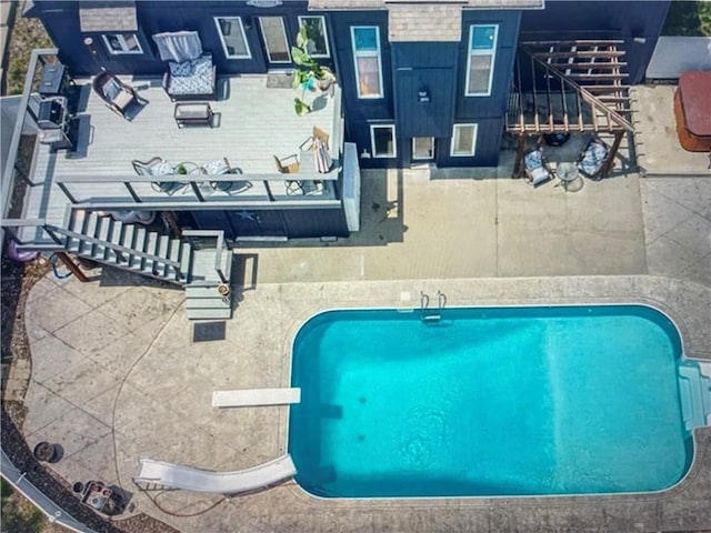 view of swimming pool with a diving board