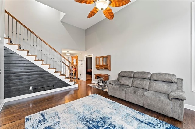 living room featuring dark hardwood / wood-style flooring, high vaulted ceiling, and ceiling fan