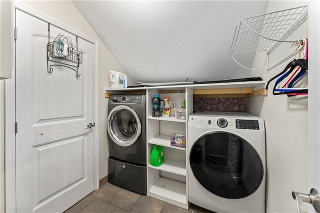 laundry area with tile patterned flooring, washer and dryer, and a textured ceiling