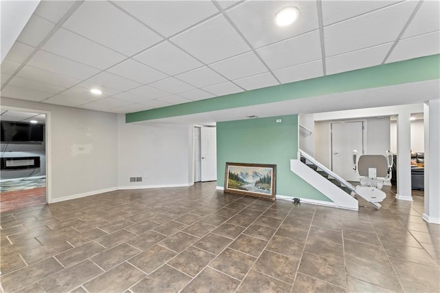 unfurnished living room featuring tile patterned floors and a drop ceiling